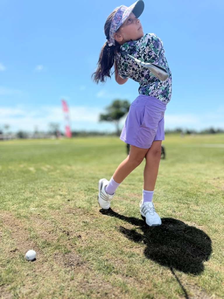 Joven golfista colombiana realizando un swing