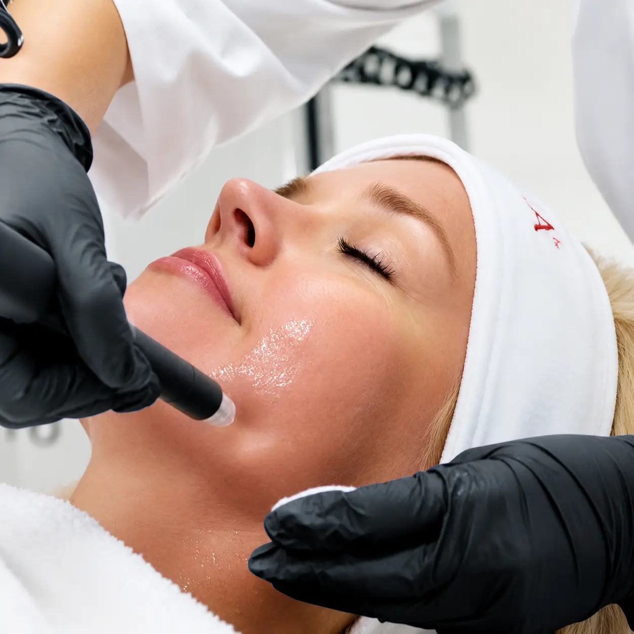 Mujer joven de 30 años aplicándose crema facial para el cuidado de la piel